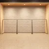 A minimalist display of three black metal clothing racks against a white brick wall and a tiled floor. Anteprima dell’immagine prodotto