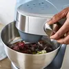 A hand is shown adjusting a knob on a Kenwood food processor while it is in use, with berries and other ingredients in the bowl. Produktbild-Vorschau