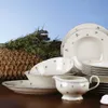 A collection of white ceramic dinnerware with a floral pattern, arranged on a wooden surface with a basket of lavender in the background. Podgląd zdjęcia produktu