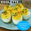 Deviled eggs garnished with bacon and chives on a blue plate. Produktbild-Vorschau