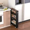 A slim rolling cart filled with jars and containers is placed next to a kitchen counter and refrigerator. Podgląd zdjęcia produktu