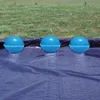 Three blue inflatable pool cushions are lined up on a dark blue tarp, with green grass in the background. Produktbild-Vorschau