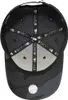 The underside of a black baseball cap with a camouflage pattern and a baseball. Produktbild-Vorschau