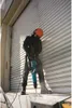 A construction worker using a jackhammer in front of a large metal door. Anteprima dell’immagine prodotto