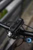 A close-up shot of a black bicycle headlight mounted on the handlebars of a bicycle. Anteprima dell’immagine prodotto