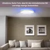 A modern living room with a sofa, framed pictures on the wall, and a ceiling light. Produktbild-Vorschau