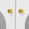 A close-up view of two golden cabinet knobs on a white surface. Podgląd zdjęcia produktu