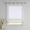 A white sheer Roman blind with a yellow floral border is displayed on a window. Produktbild-Vorschau