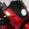 Close-up of the front of a red three-wheeled scooter, showing the headlight and turn signal. Produktbild-Vorschau