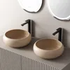 Two beige ceramic washbasins with black faucets are displayed on a gray cabinet. Anteprima dell’immagine prodotto