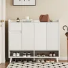 A white shoe cabinet with a drawer and four doors, placed in an entryway with a rug and an umbrella stand. Anteprima dell’immagine prodotto