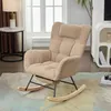 A beige corduroy rocking chair with a headrest is shown in a living room setting, next to a side table with a lamp and a window with curtains. Náhľad obrázku produktu