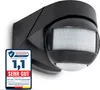 A black motion detector mounted on a wall, with a quality seal in the foreground. Náhľad obrázku produktu