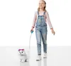 A young girl walks a toy dog on a leash against a white background. Náhled obrázku produktu