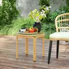A small round table with a fruit tray and a vase of flowers on a wooden deck, with lush greenery in the background. Podgląd zdjęcia produktu