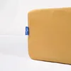 A close-up shot of a mustard yellow fitted sheet with a blue brand tag attached to the side. Náhled obrázku produktu