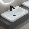 A modern white sink with a black faucet is shown on a dark countertop. Produktbild-Vorschau