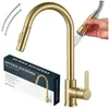 A gold kitchen faucet with a pull-out spray head is shown, along with its packaging and flexible hoses. Produktbild-Vorschau