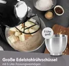 A close-up shot of a black stand mixer with a silver bowl filled with ingredients. Produktbild-Vorschau