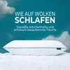A white pillow with green trim rests on a white surface, with a teal sky and clouds in the background. Produktbild-Vorschau