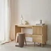 A light wood desk with two drawers and a ribbed front panel, a modern stool, and a desk lamp. Produktbild-Vorschau