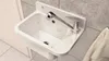 A white sink with a silver faucet is mounted on a tiled wall. Anteprima dell’immagine prodotto