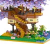 A detailed view of a constructed model of a treehouse with purple cherry blossoms, surrounded by greenery and water. Náhľad obrázku produktu