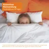 A child peeking out from under a white blanket in bed, with orange pillows in the background. Náhled obrázku produktu