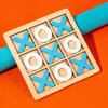 A wooden tic-tac-toe board with blue X's and white O's, placed on an orange textured surface with a blue ribbed object behind it. Náhled obrázku produktu