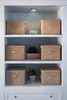 A white shelving unit with several woven storage boxes and a small potted plant. Anteprima dell’immagine prodotto