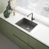 A modern kitchen sink and faucet setup with decorative vases on a white countertop. Podgląd zdjęcia produktu