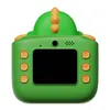 A green toy camera shaped like a dinosaur, shown from the back. Voir les images du produit