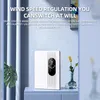 A white dehumidifier is placed on a blue cabinet next to a plant and a vase with flowers. Produktbild-Vorschau