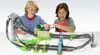 Two boys playing with a Hot Wheels Mario Kart race track. Produktbild-Vorschau