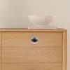 A close-up shot of a wooden dresser with a single drawer pull. Podgląd zdjęcia produktu