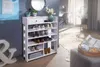 A white shoe rack filled with shoes, placed in a room with a mirror and a vase of flowers on top. Produktbild-Vorschau