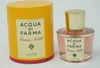 A perfume bottle and its cylindrical packaging are displayed against a white background. Podgląd zdjęcia produktu