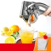 A hand is shown using a manual citrus juicer to squeeze juice into a glass, with fresh citrus fruits and slices around it. Náhľad obrázku produktu