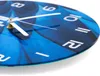 A close-up, angled view of a round wall clock with a blue abstract design and white numbers and hands. Produktbild-Vorschau