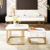 A modern living room scene featuring a white marble-look coffee table set with gold accents, placed on a patterned rug in front of a white entertainment center and a large television. Voir les images du produit