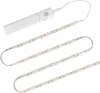 A white LED light strip with a motion sensor module attached to one end, laid out in a serpentine pattern on a white background. Anteprima dell’immagine prodotto