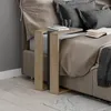 A close-up view of a C-shaped side table next to a bed. Anteprima dell’immagine prodotto