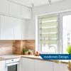 A modern kitchen with white cabinets, a wooden backsplash, and a window with a green roller blind. Produktbild-Vorschau