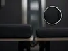 A close-up view of two black seat cushions on a light-colored surface, with a magnified inset of one cushion's fabric texture. Produktbild-Vorschau