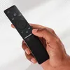 A hand holding a black remote control. Anteprima dell’immagine prodotto