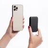 Two hands holding a smartphone and a power bank. Anteprima dell’immagine prodotto