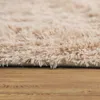 A close-up view of a shaggy rug on a wooden floor. Anteprima dell’immagine prodotto