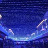 A street or walkway decorated with numerous blue LED string lights hanging from above. Náhled obrázku produktu