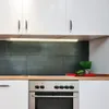 A kitchen scene with white cabinets, a dark tiled backsplash, a wooden countertop, and a stainless steel oven. Náhľad obrázku produktu