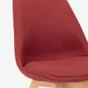 A close-up view of a red upholstered chair with wooden legs. Produktbild-Vorschau